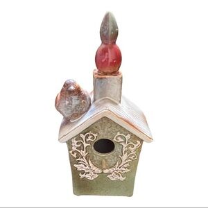 CERAMIC birdhouse with deco front, perch, chimney and bird beside it.